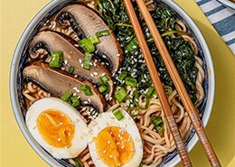 bowl of noodles with boiled egg and mushrooms