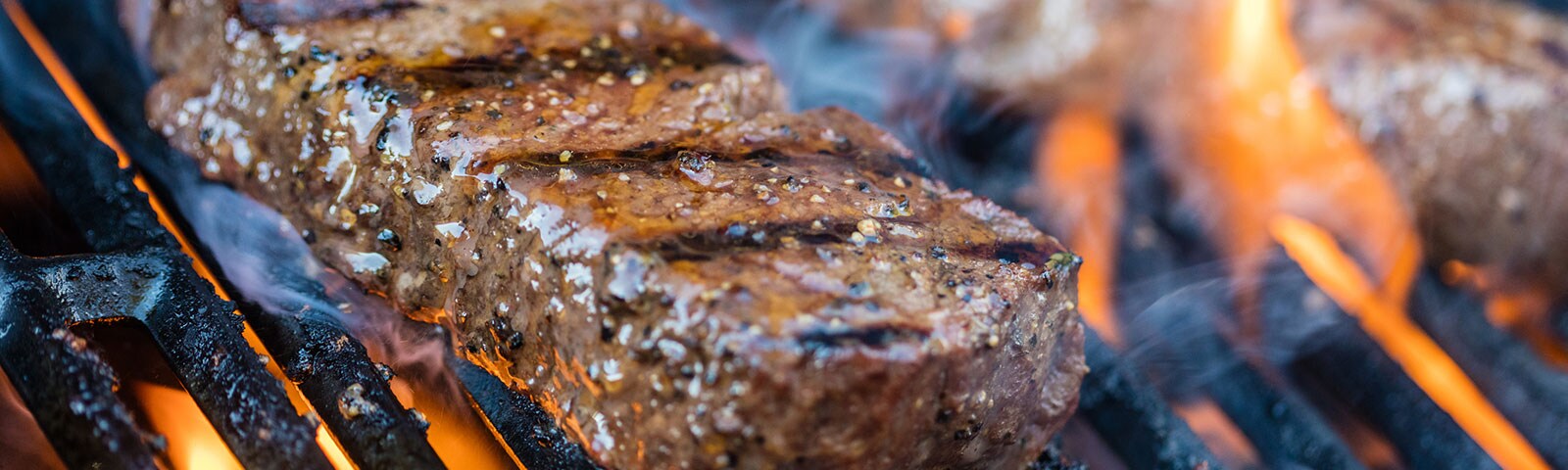 Cooked steak grilling on a grill Cooked steak grilling on a grill