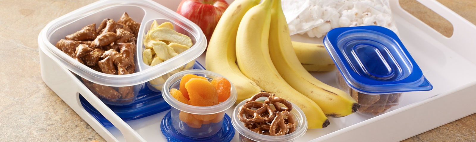 Containers of snacks on a white tray Containers of snacks on a white tray