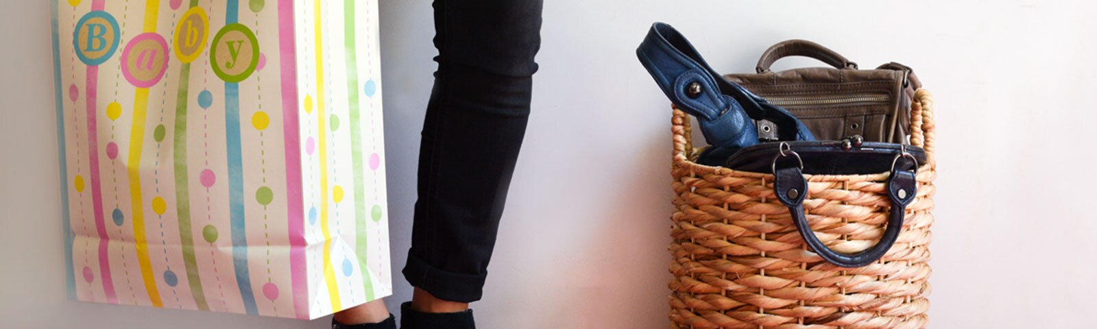 Person standing with baby bag and black skinny jeans Person standing with baby bag and black skinny jeans