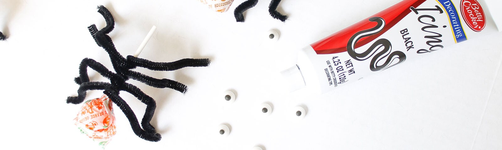 DIY spider suckers with black pipe cleaners attached to lollipops DIY spider suckers with black pipe cleaners attached to lollipops