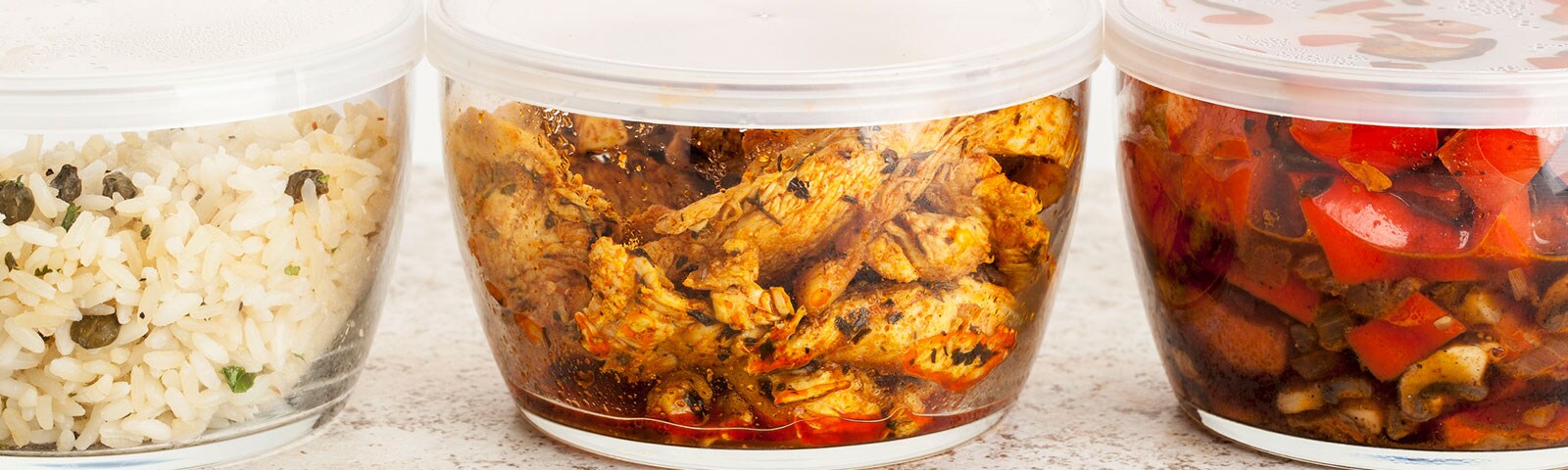 Three food storage containers, each with a different dish inside